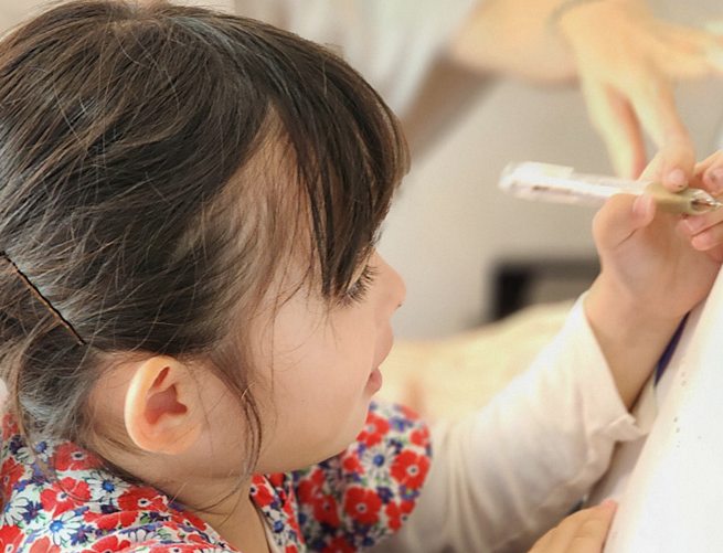 リトミックを楽しむ子どもと講師の写真